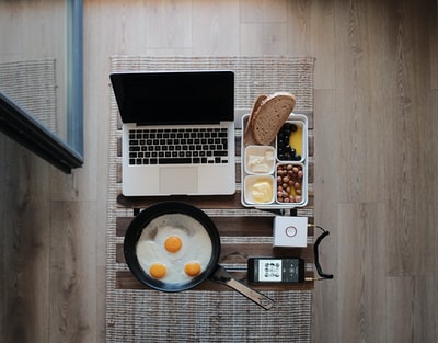 MacBookPro的照片，灰色垫子上放着鸡蛋和面包的煎锅